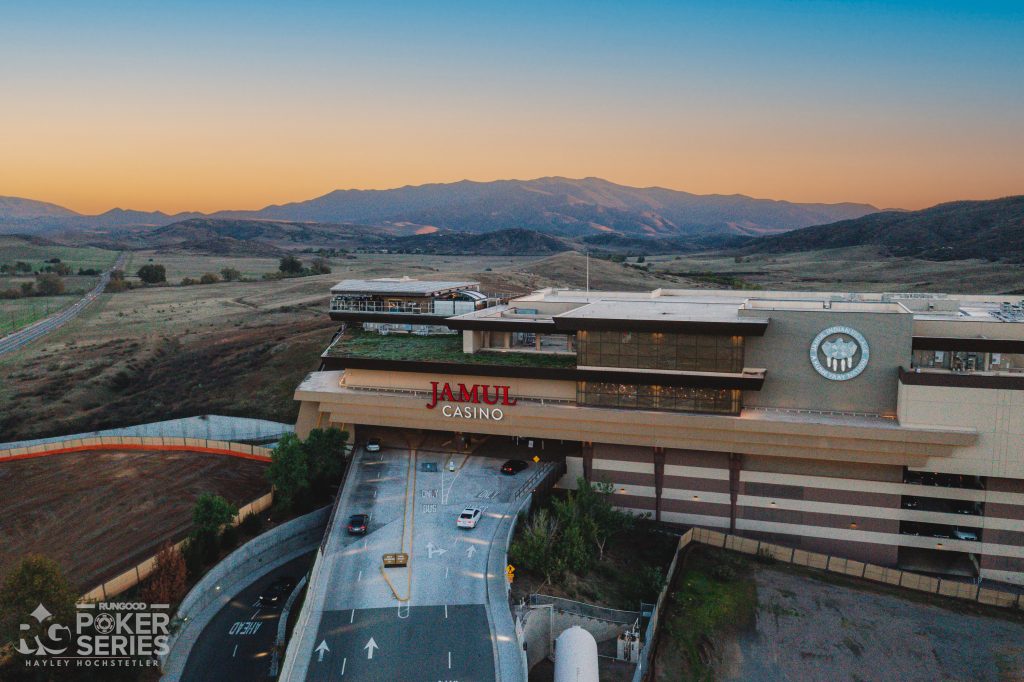 a building with a large parking lot and mountains in the background